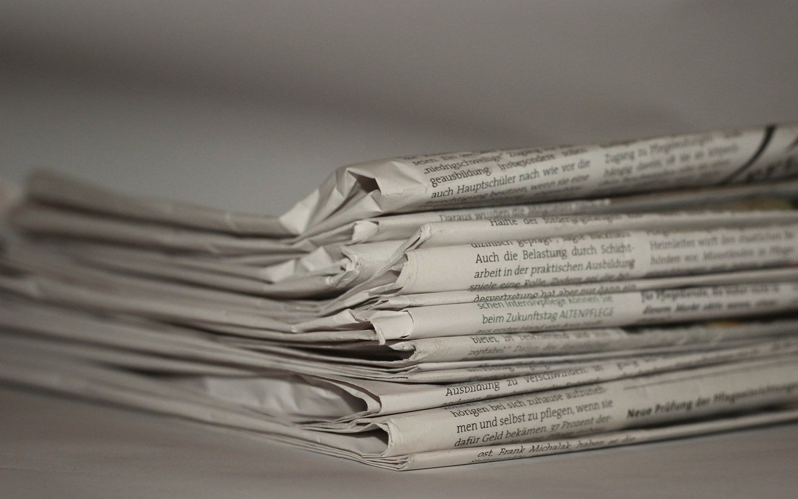 A stack of folded German-language newspapers viewed close up at eye level